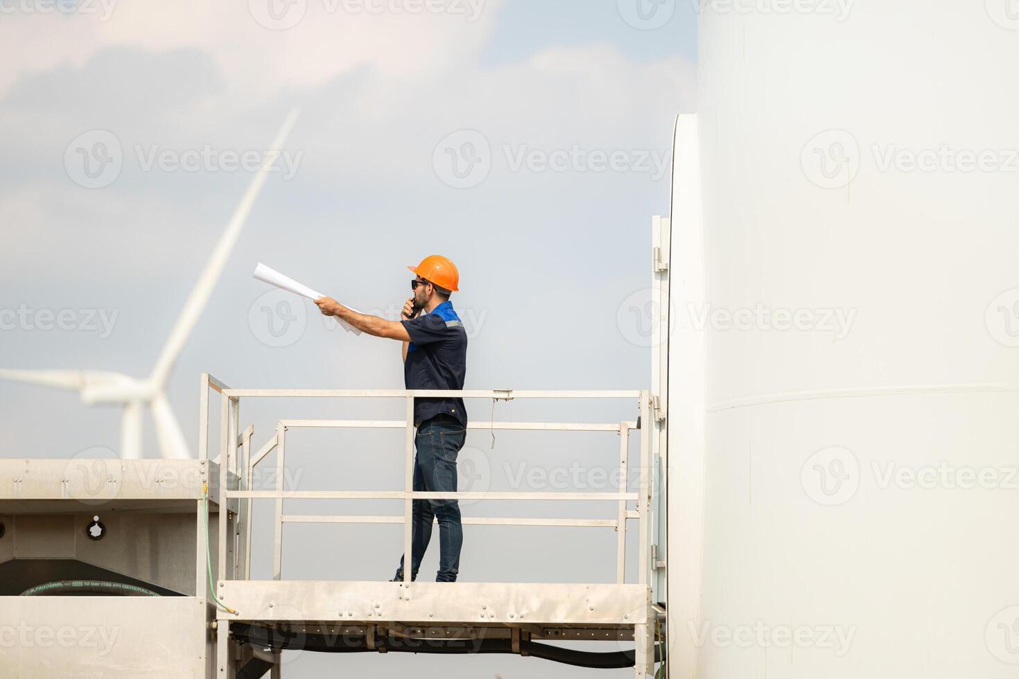 Technician checking wind turbine in wind turbine farm for maintenance. photo