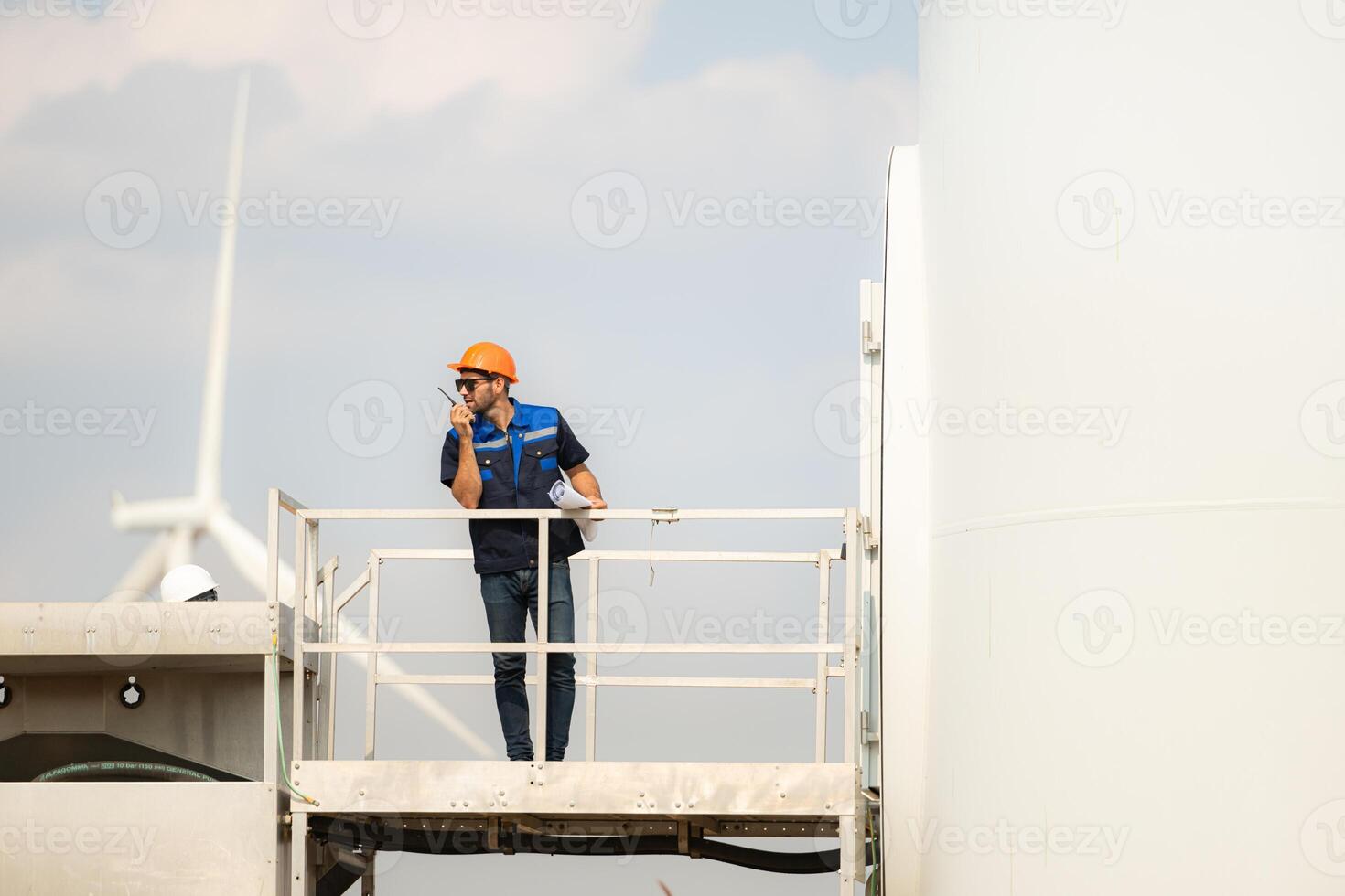 Technician checking wind turbine in wind turbine farm for maintenance. photo