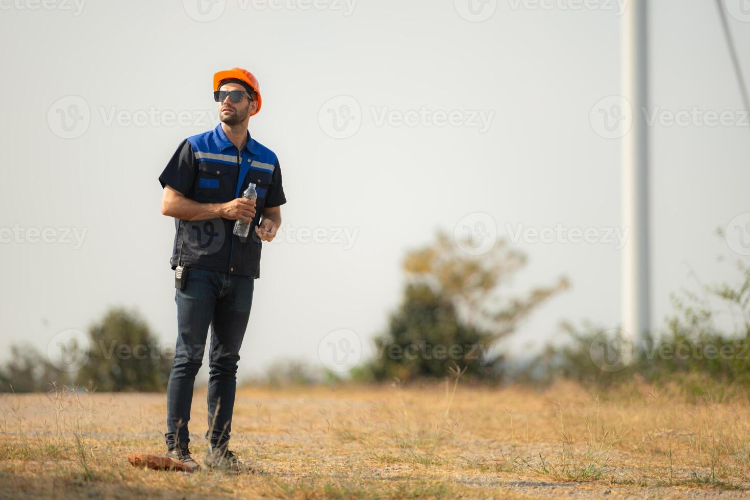 Engineer working in wind turbine farm with blue sky background photo