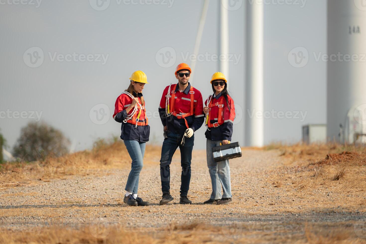 Team of engineers working on wind turbines in a wind farm photo