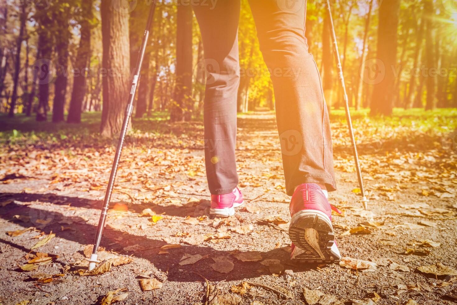 Woman nordic walking outdoors feet close up photo