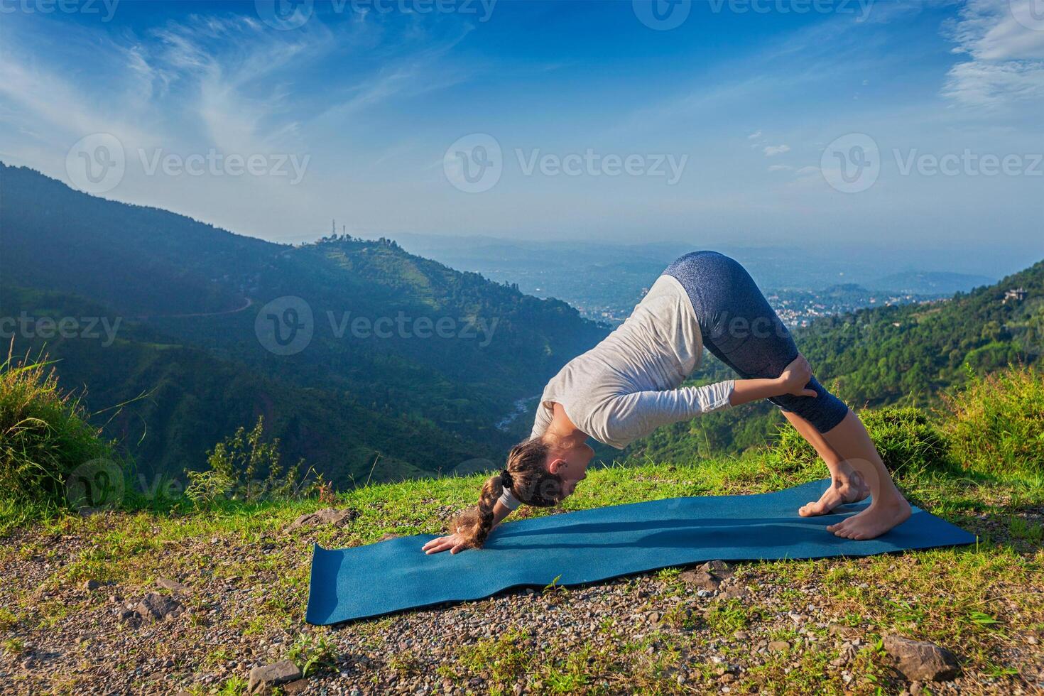Young sporty fit woman doing yoga oudoors in mountains photo