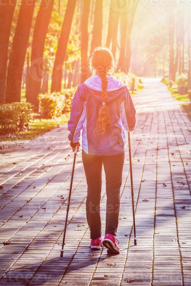 Woman nordic walking outdoors photo