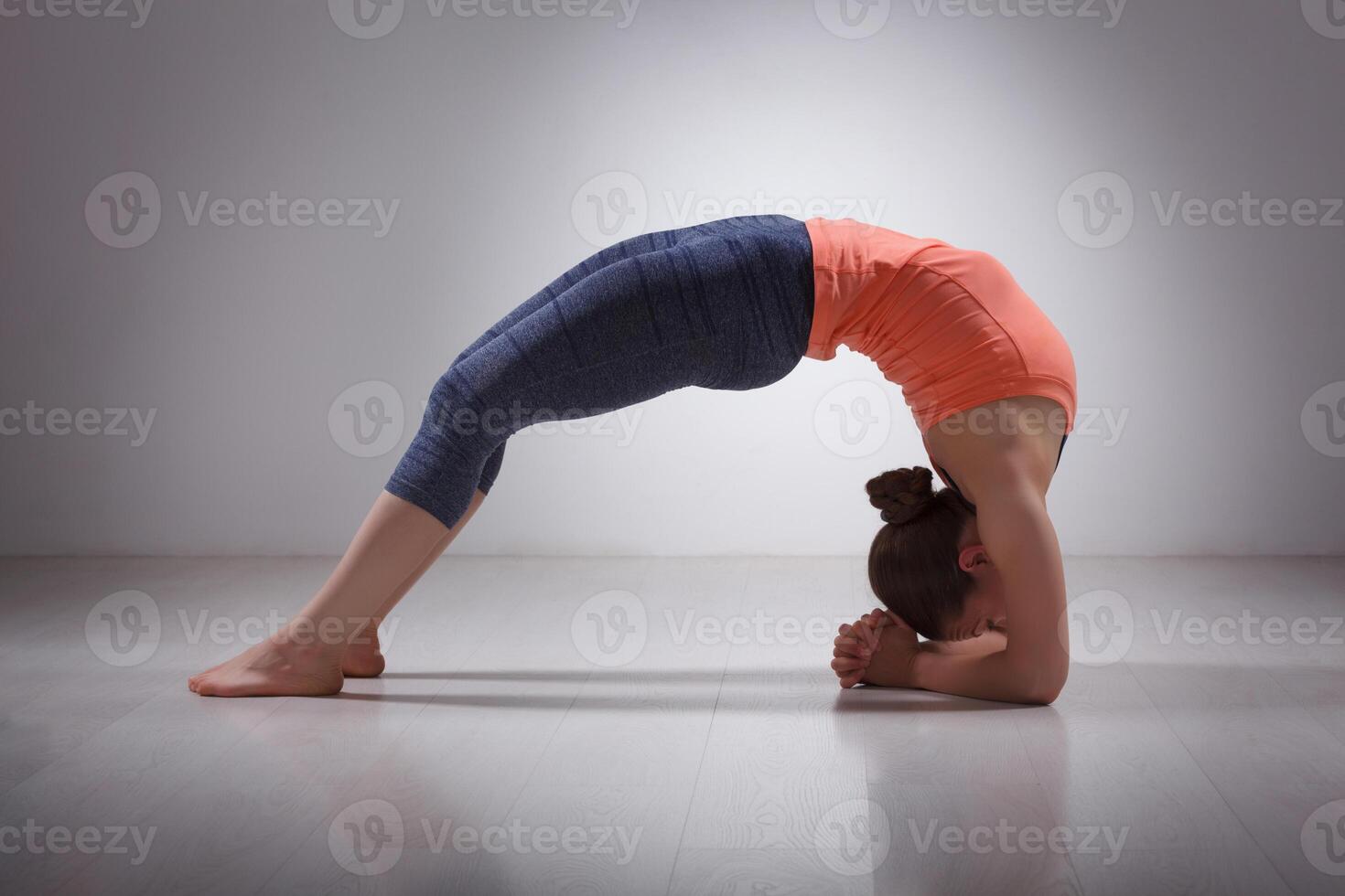 Beautiful sporty fit yogi girl practices yoga asana viparita dan photo
