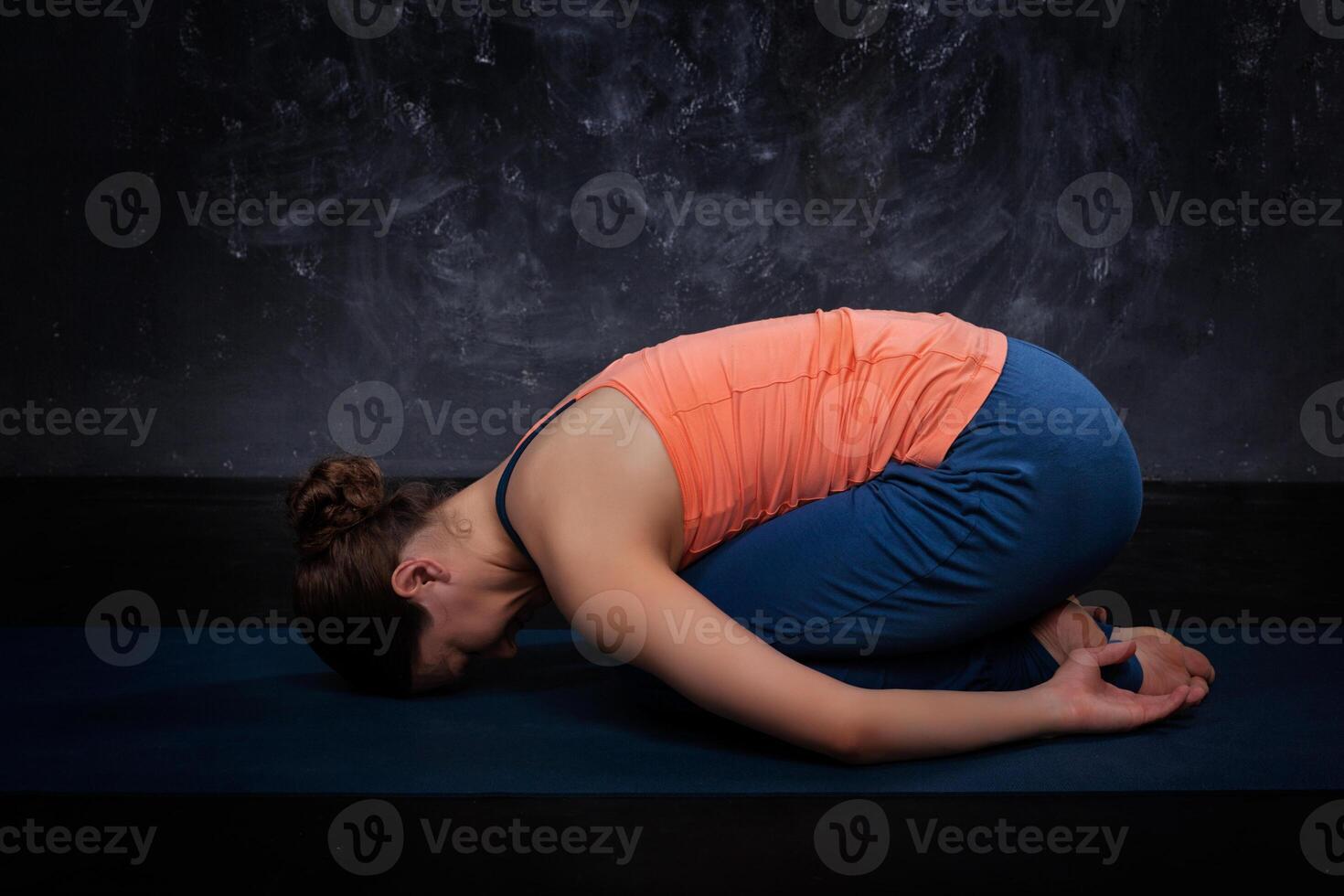 Beautiful sporty fit yogi girl practices yoga asana balasana photo