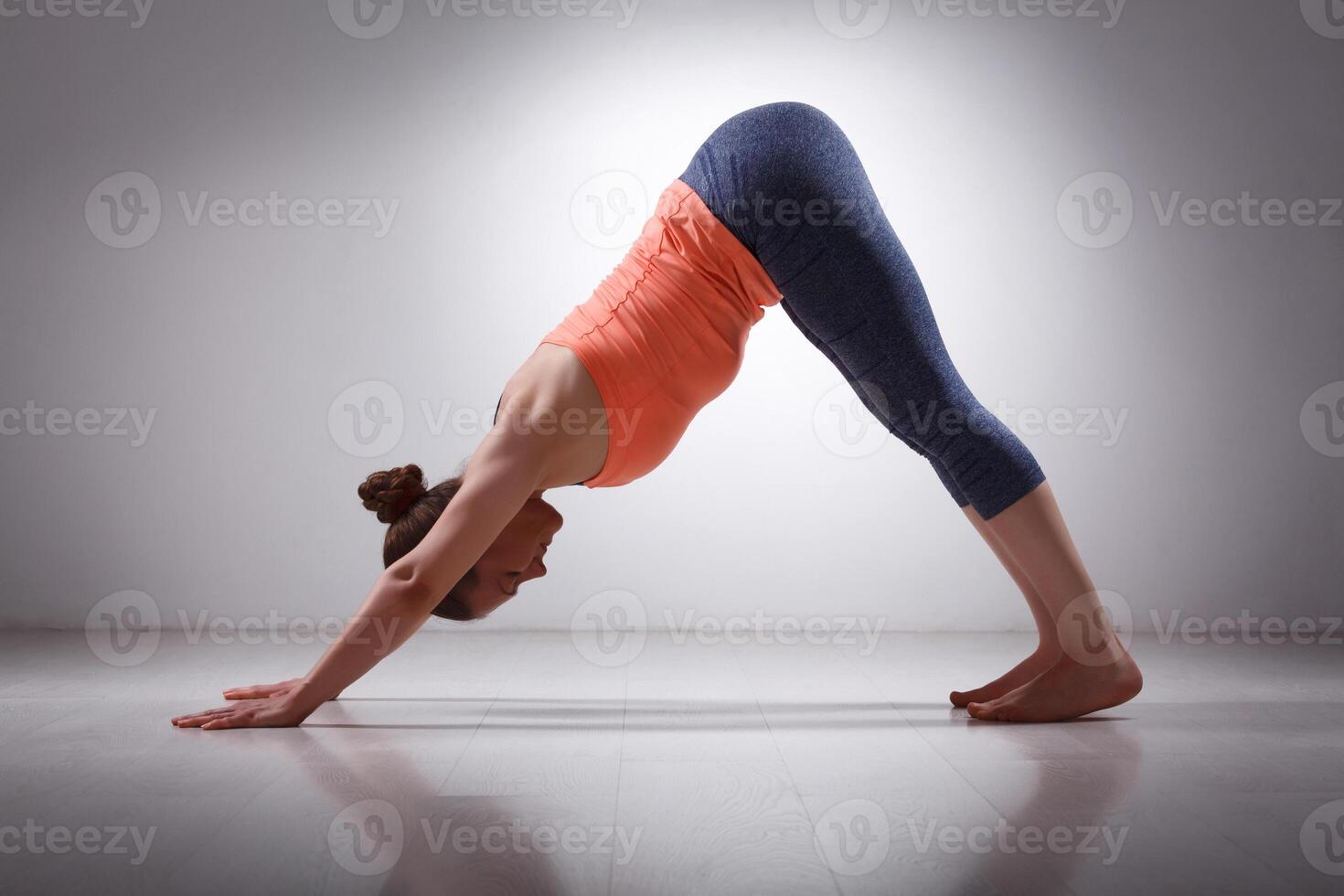 Beautiful sporty fit yogi girl practices yoga asana adhomukha sv photo