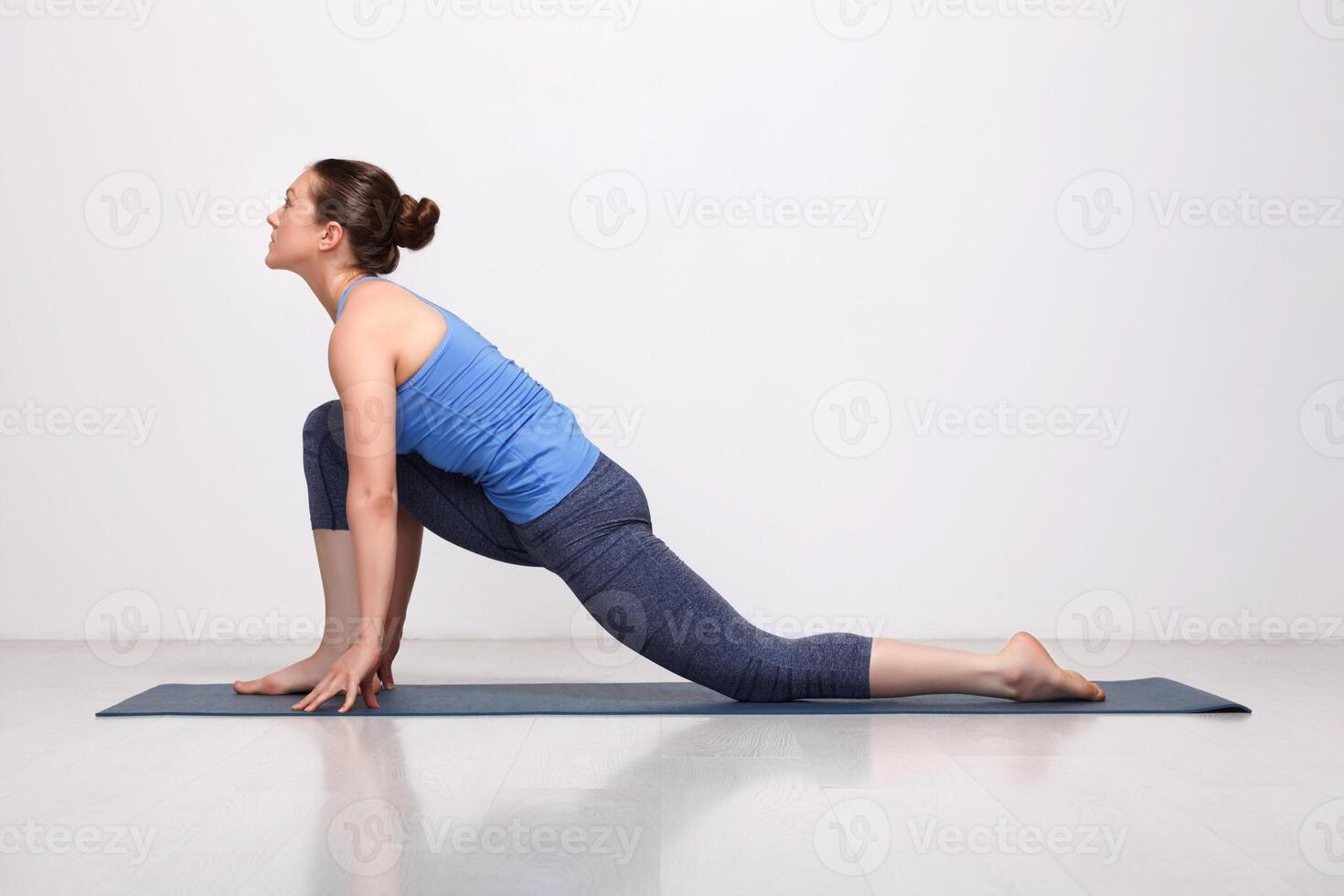 Fit yogini woman practices yoga asana Anjaneyasana photo