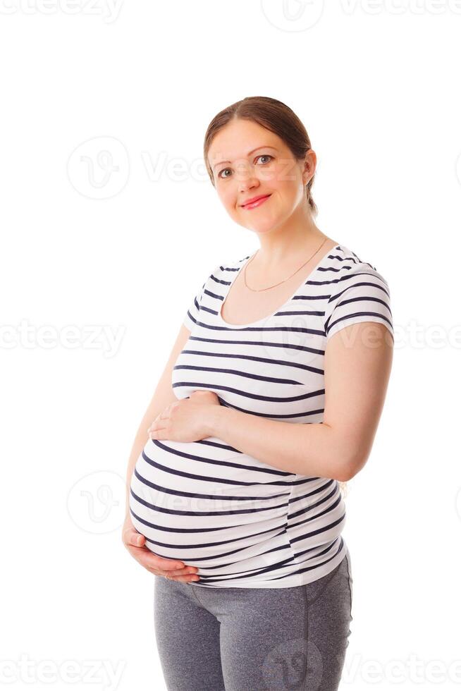 Pregnant woman standing embracing her belly photo