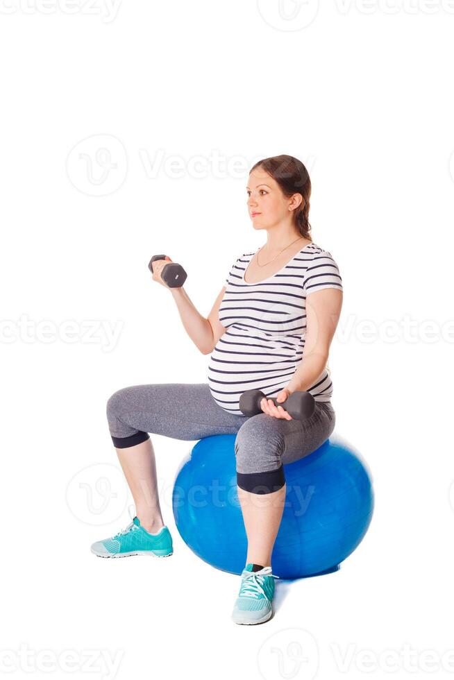 Pregnant woman doing exercises with exercise ball photo