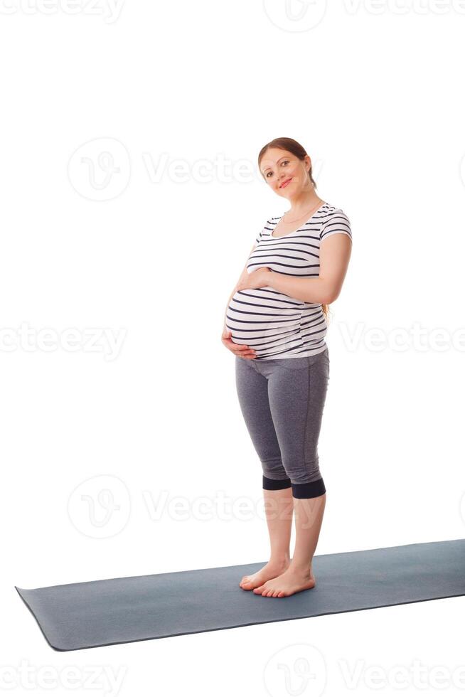 Pregnant woman standing embracing her belly photo