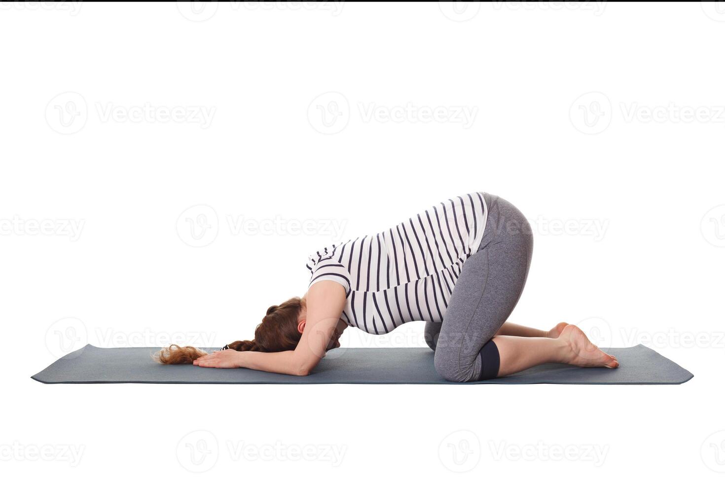Pregnant woman doing yoga asana Balasana child pose photo