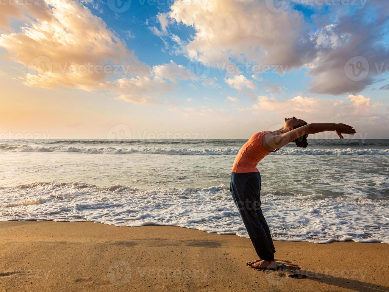 mujer haciendo yoga Dom saludo surya namaskar foto