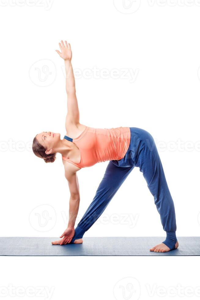 Sporty fit woman practices yoga asana utthita trikonasana photo