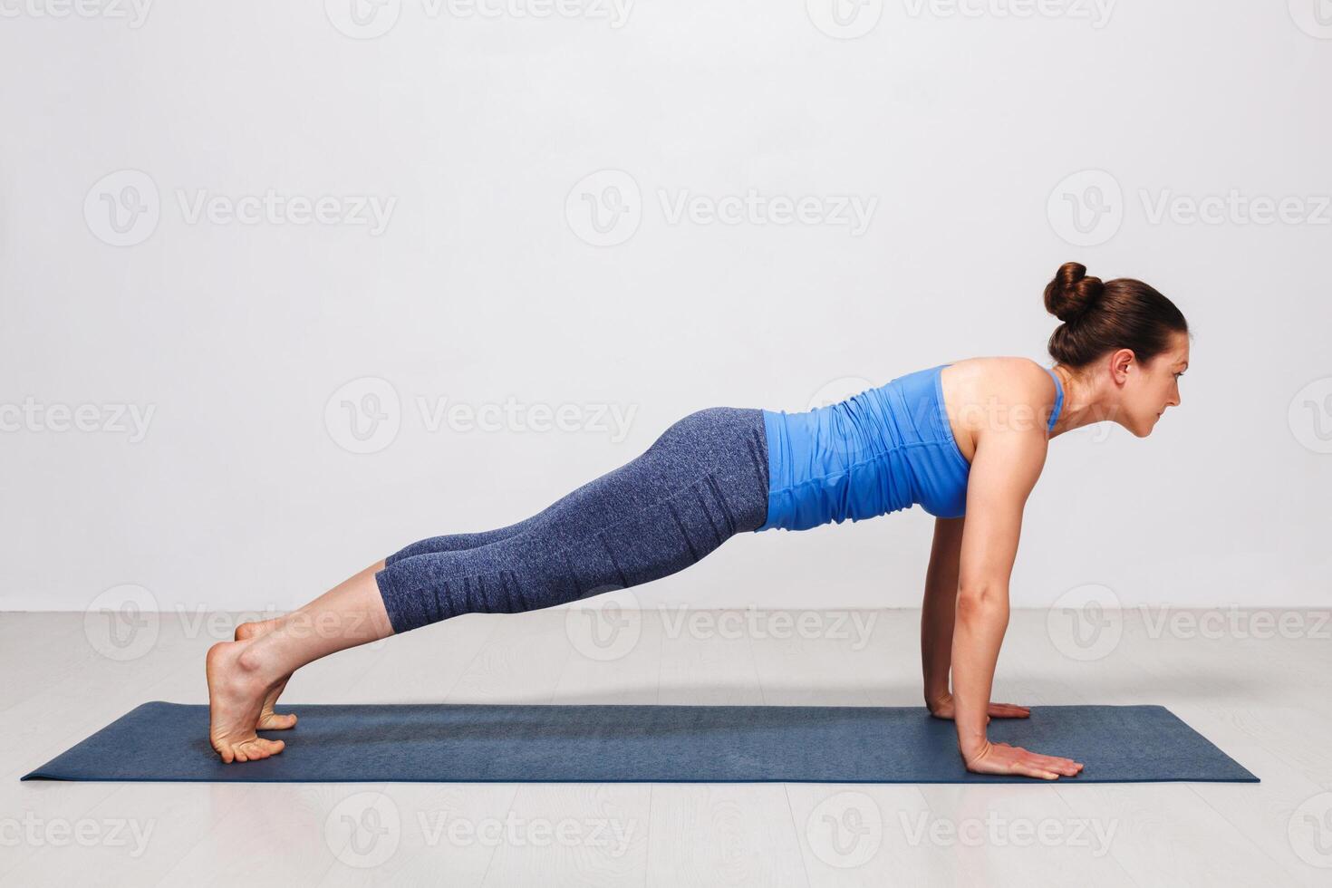 Woman doing yoga Surya Namaskar Sun Salutation asana Utthita cha photo