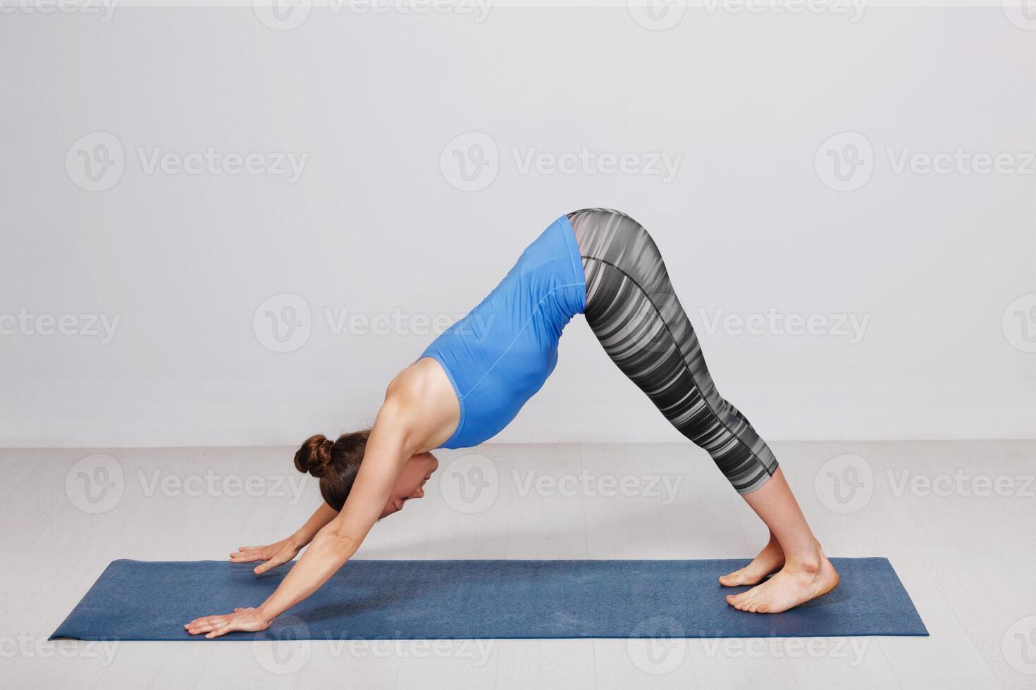 Woman doing Ashtanga Vinyasa yoga asana Adhomukha svanasana photo