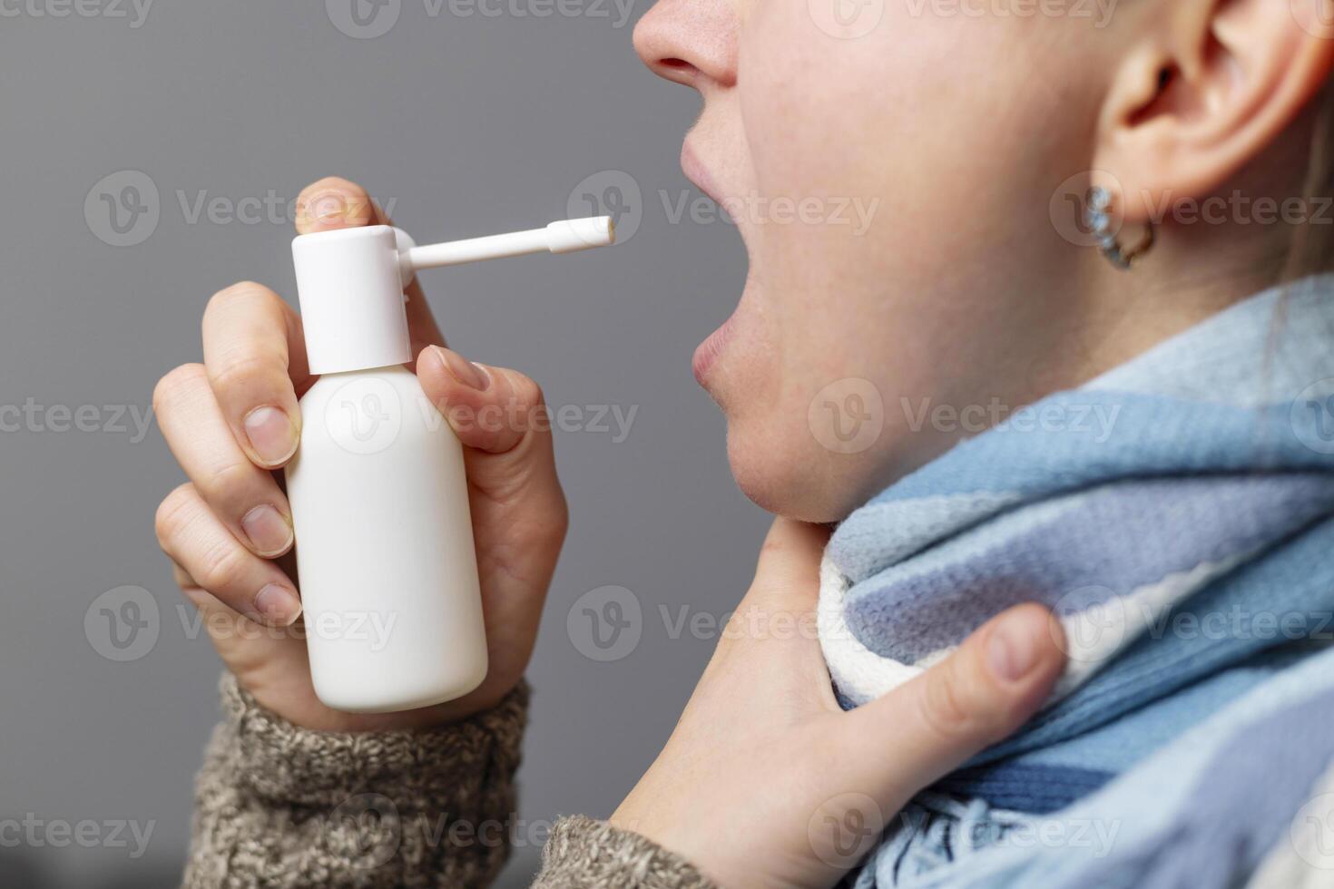 persona utilizando garganta rociar para dolorido garganta alivio foto