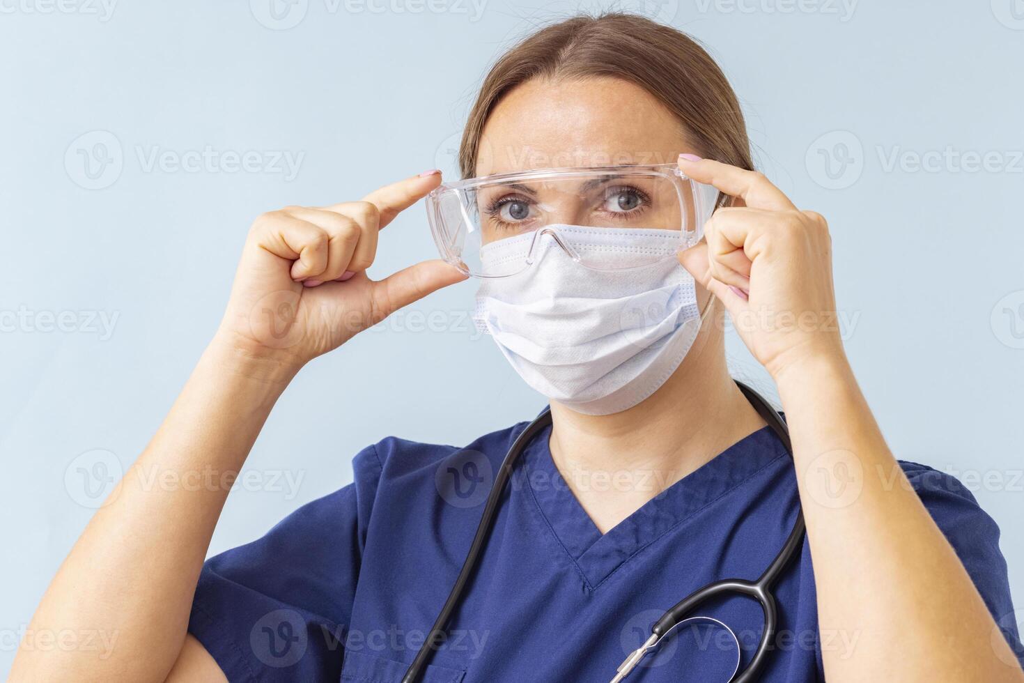 Female Nurse Adjusting Protective Eyewear photo