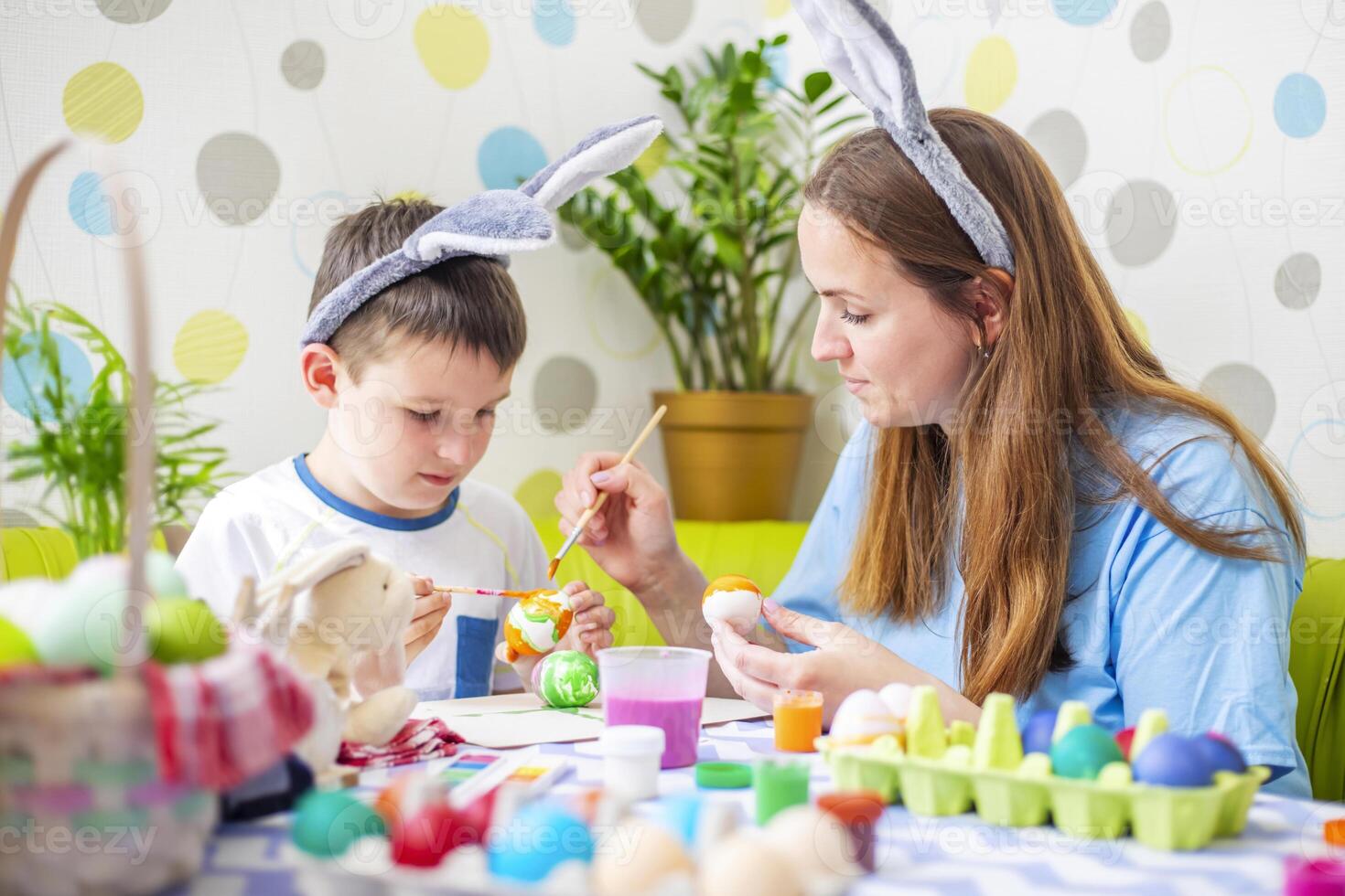 Happy Easter. A mother and her son painting Easter eggs photo