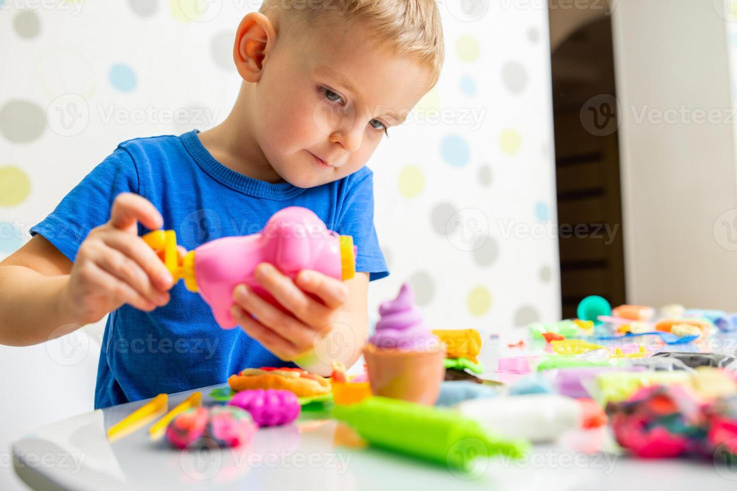 linda niños sentado a el mesa y obras de teatro con plastilina foto