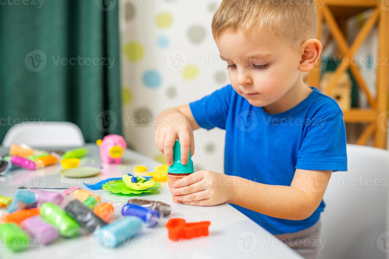 linda niños sentado a el mesa y obras de teatro con plastilina foto