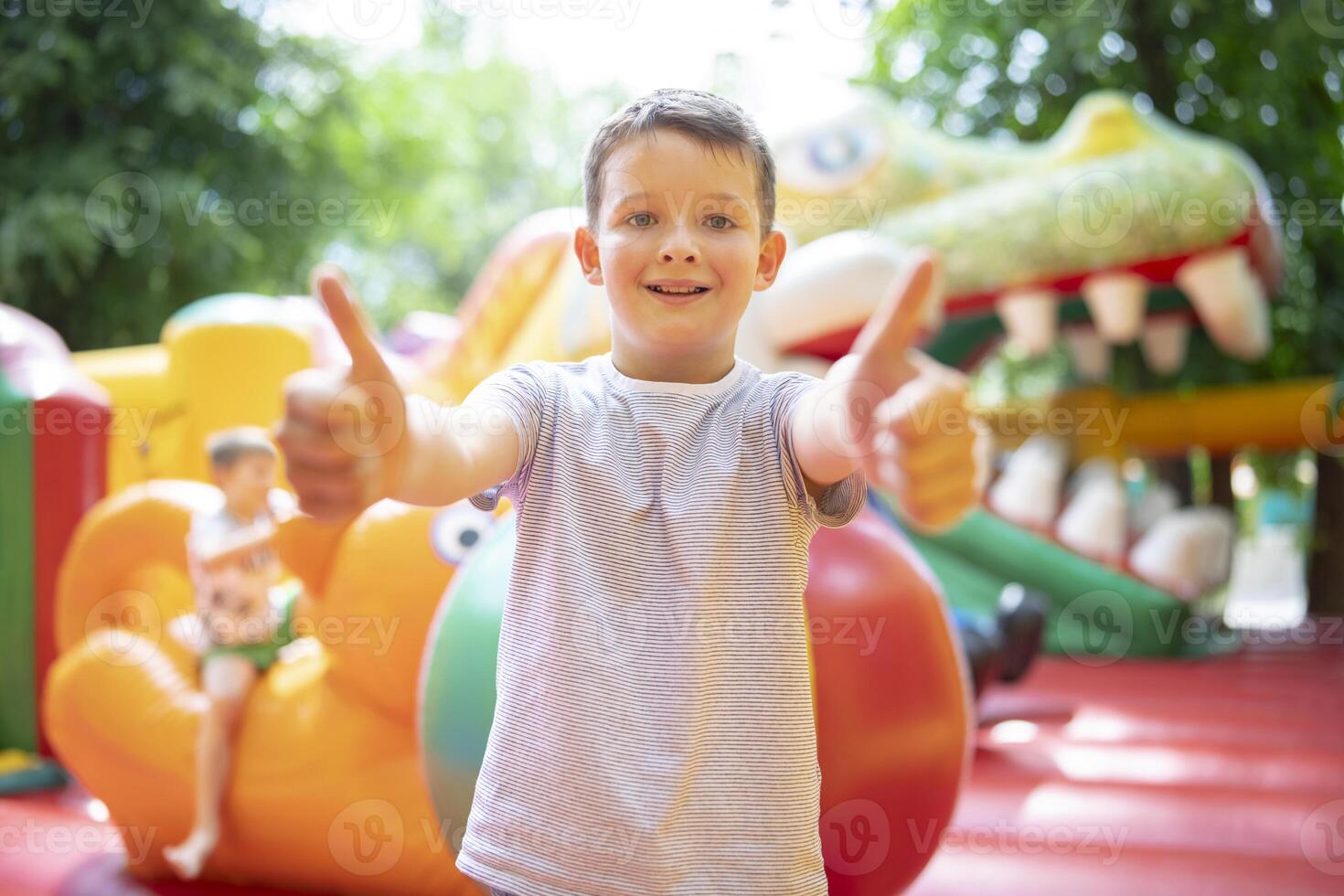 Happy boy having a lots of fun on a colorful inflate castle photo