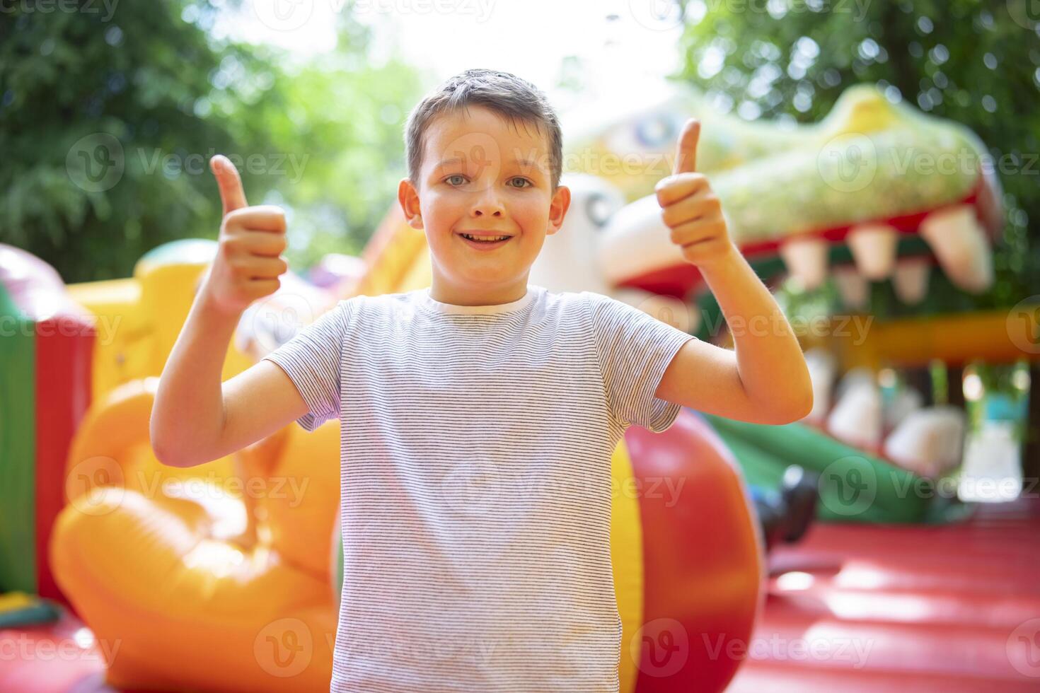 Happy boy having a lots of fun on a colorful inflate castle photo