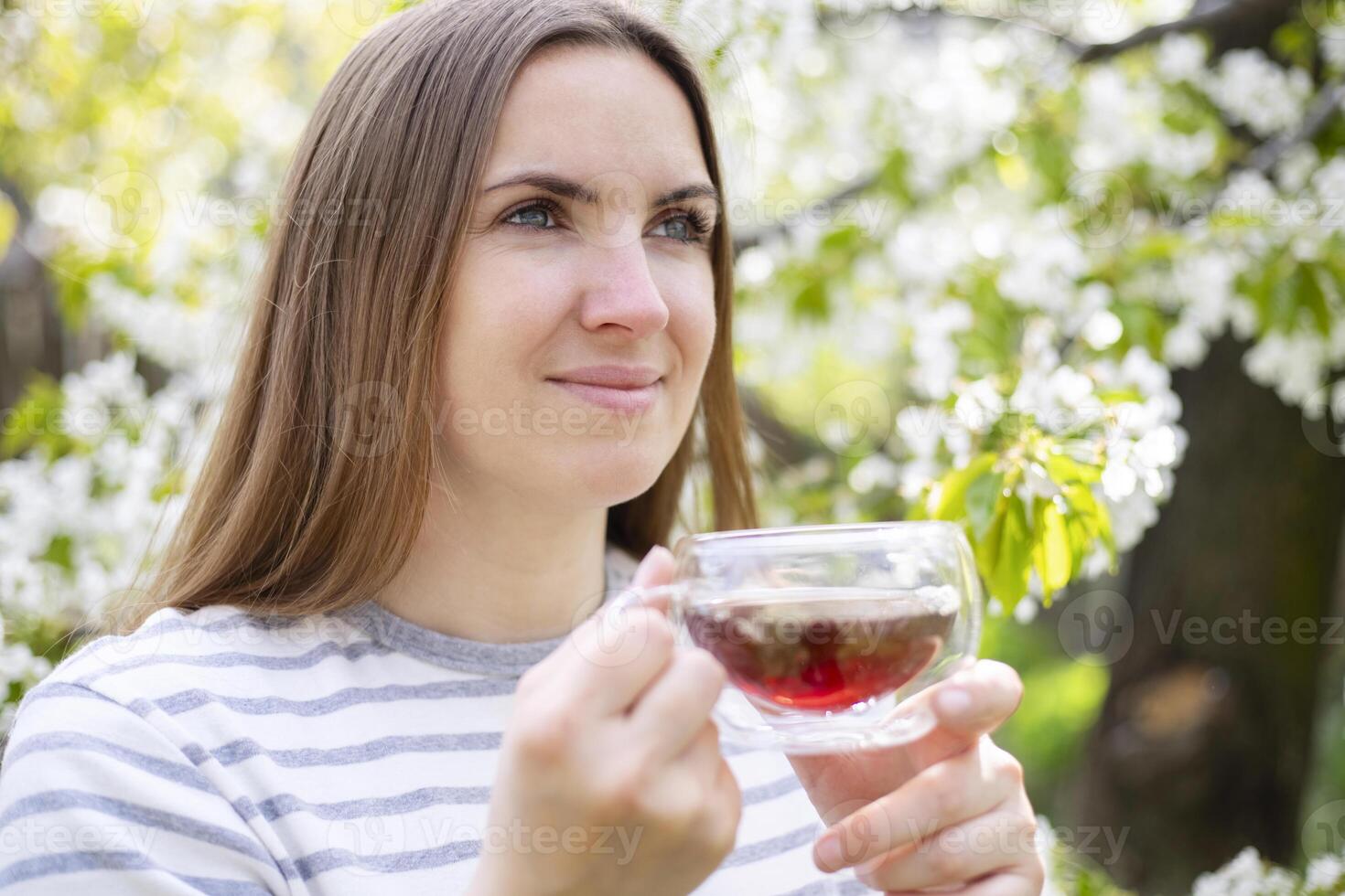Woman Enjoying Tea in Springtime Blossom photo