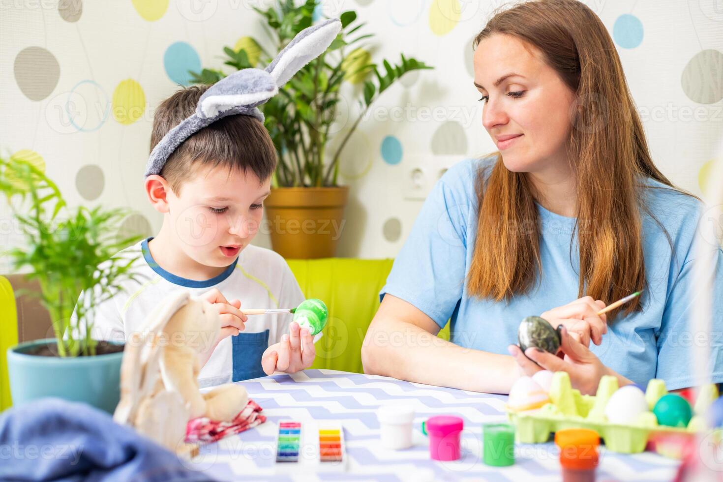 Happy Easter. A mother and her son painting Easter eggs photo