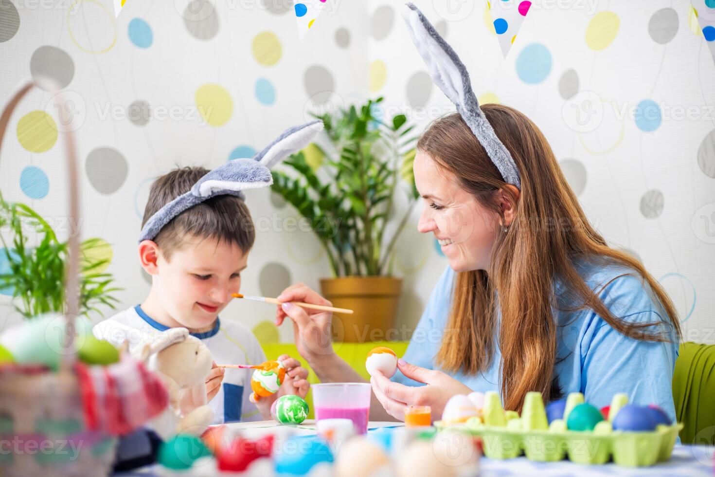 Happy Easter. A mother and her son painting Easter eggs photo