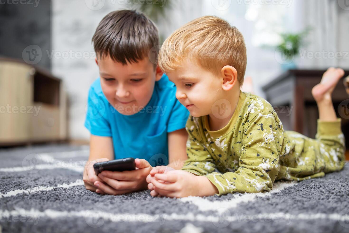 Two children watching smart phone, happy kids using smartphones together photo