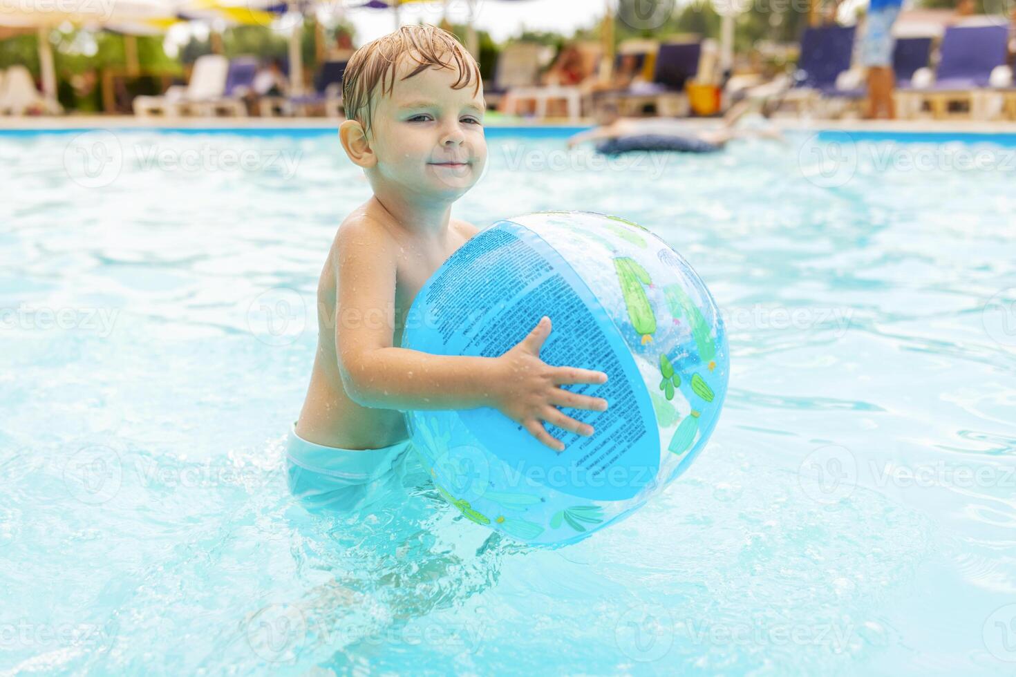 Kid swim, dive, leisure and playing inflatable ball in pool at vacation photo