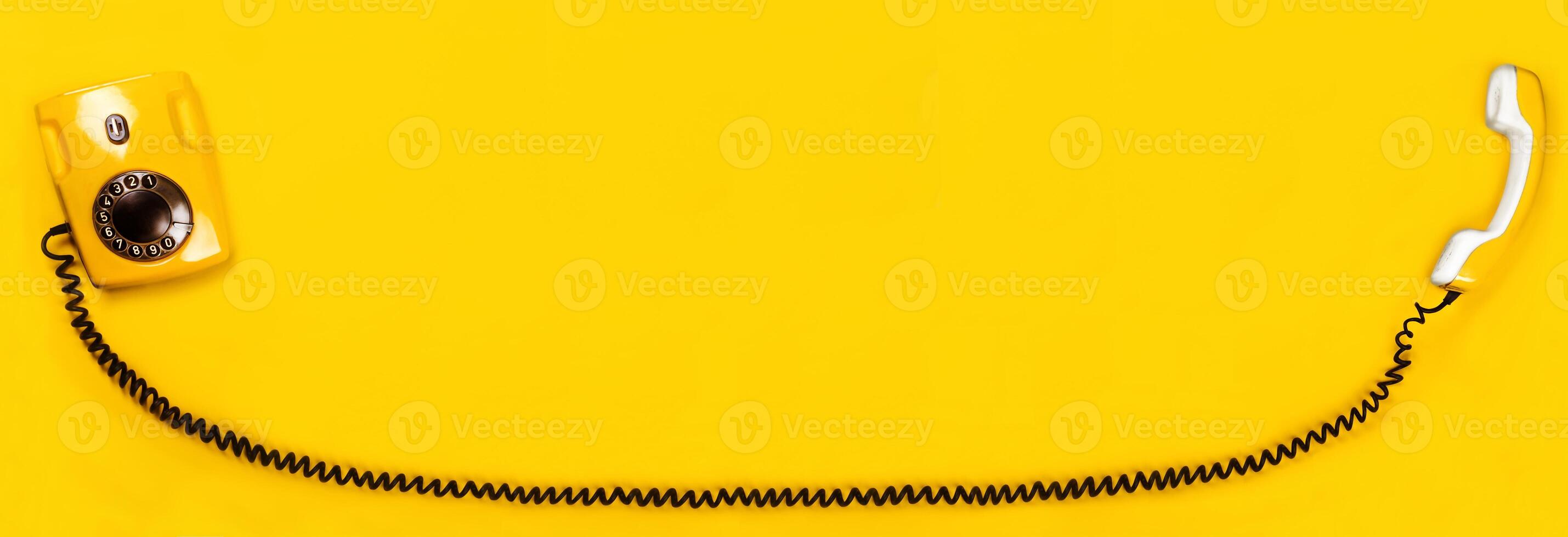 Yellow old stylish Phone, telephone with dial on yellow background copy space for your text banner photo