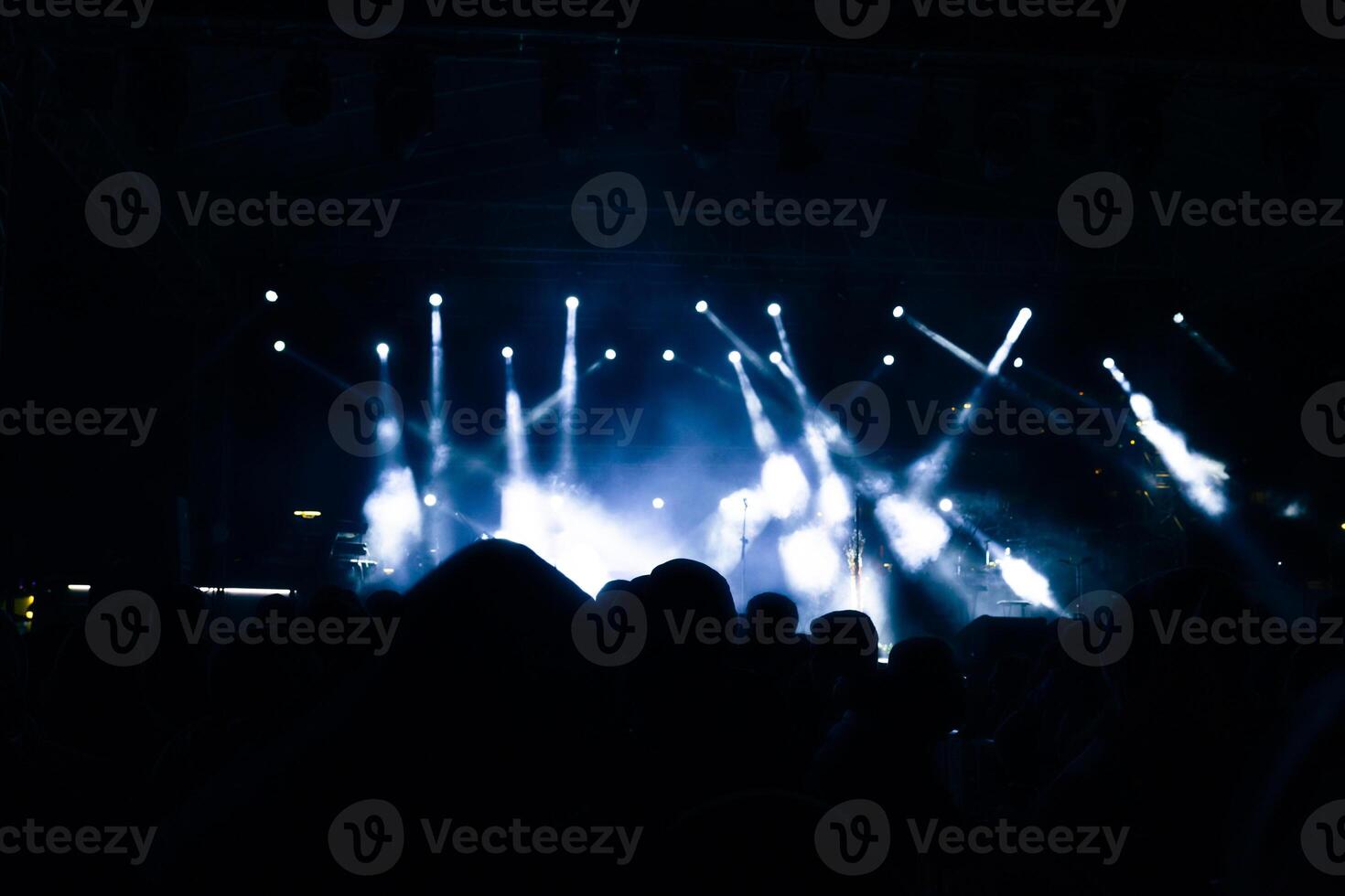 Spotlights on the stage. Silhouette of people in a concert. photo