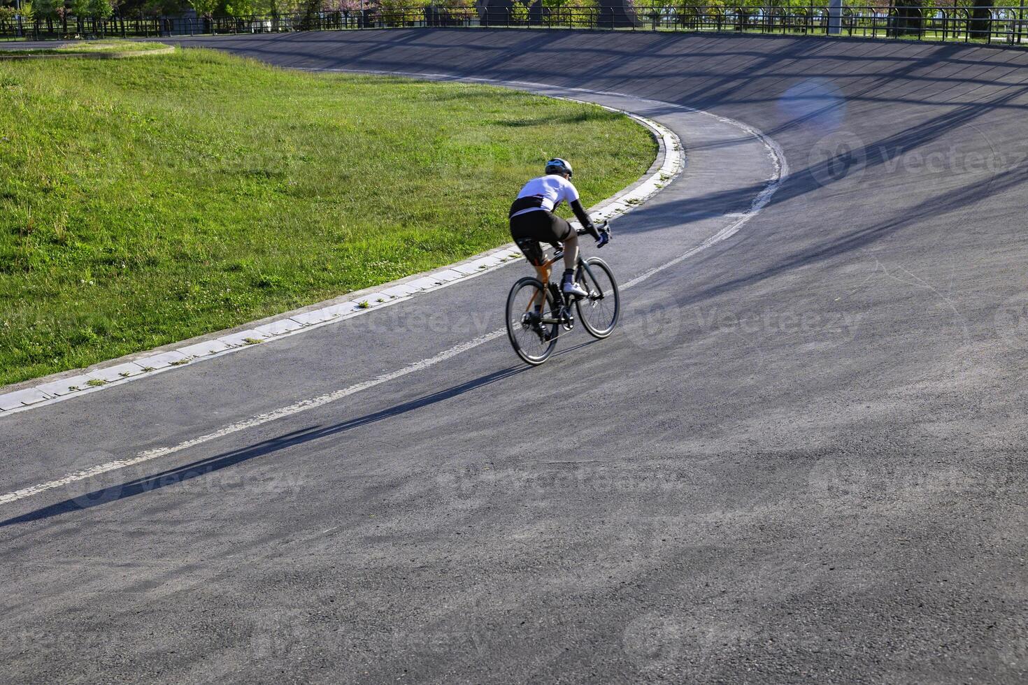 Cyclist training on the cycle-racing track in the park. Biker or bicycle sport photo