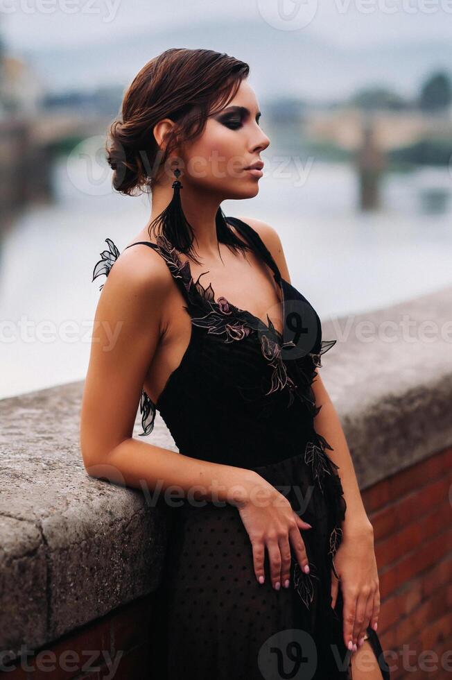 A beautiful stylish bride in a black dress walks through Florence, a Model in a black dress in the old city of Italy photo