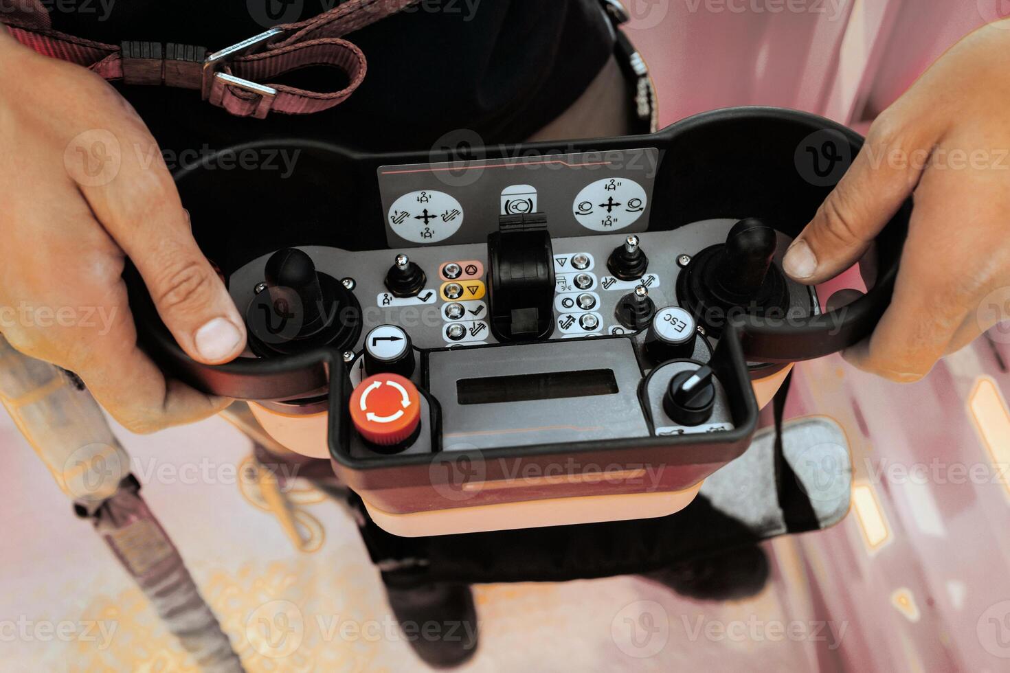 Remote control of a lifting car crane in the hands of a person. Panel with joysticks and buttons for controlling the telescopic bucket of the crane. photo