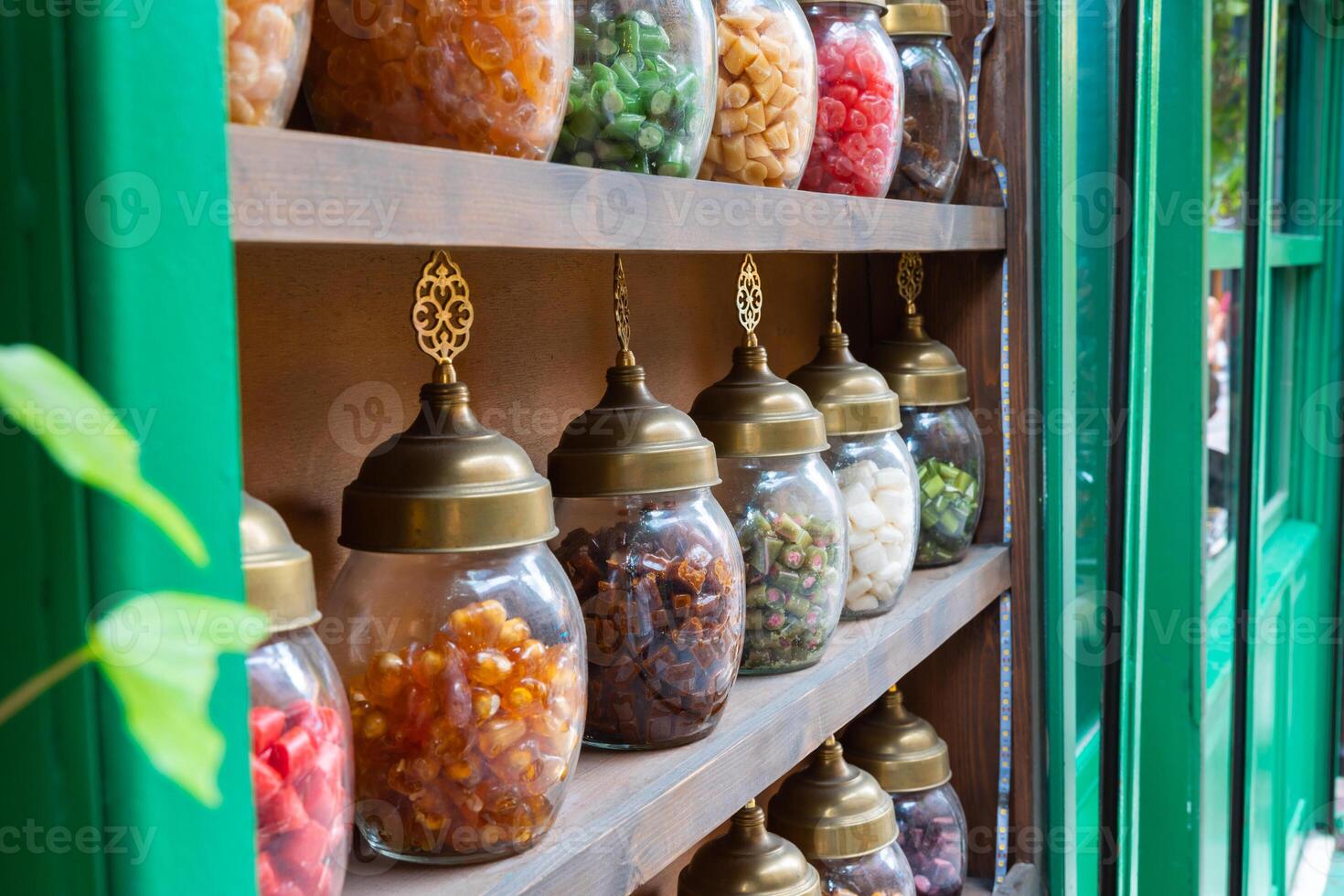 Candy jars on the shelf of the candy shop in the street. photo