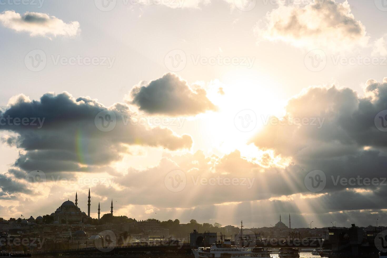 Silhouette of the cityscape of Istanbul with sun rays through the clouds photo