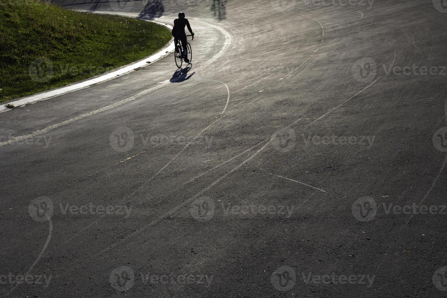 abierto aire carrera de bicicletas pista con un ciclista a puesta de sol en el parque. foto