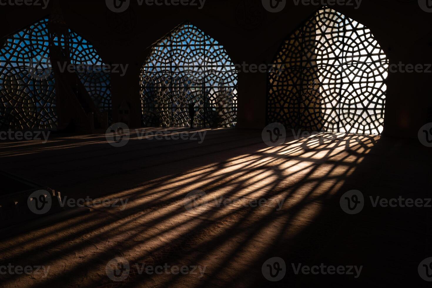 Islamic concept photo. Islamic pattern on the window and shadows on the ground photo