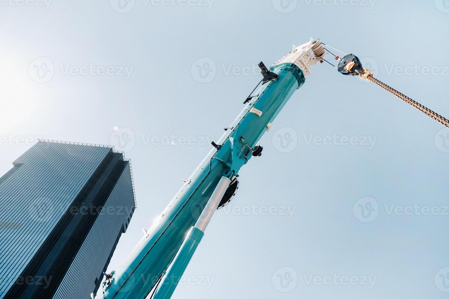 azul grua levantamiento mecanismo con manos cerca el vaso moderno edificio, grua y hidráulico alto levantar arriba a 120 metros foto