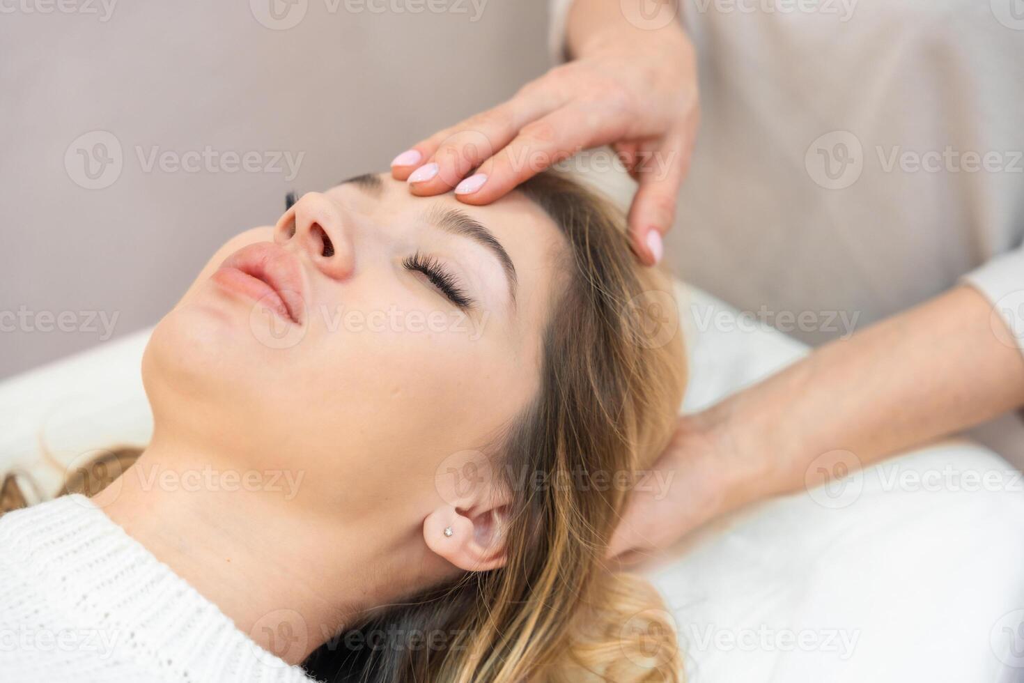 Healer performing by lightly touched set of 32 points of access bars on woman head, stimulating positive change thoughts and emotions. Alternative medicine concept photo