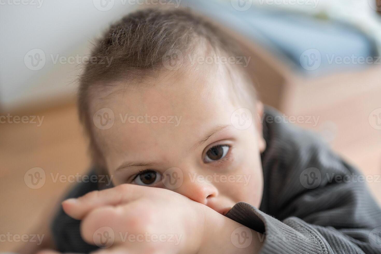 retrato de pequeño chico con abajo síndrome en hogar dormitorio. alto calidad foto