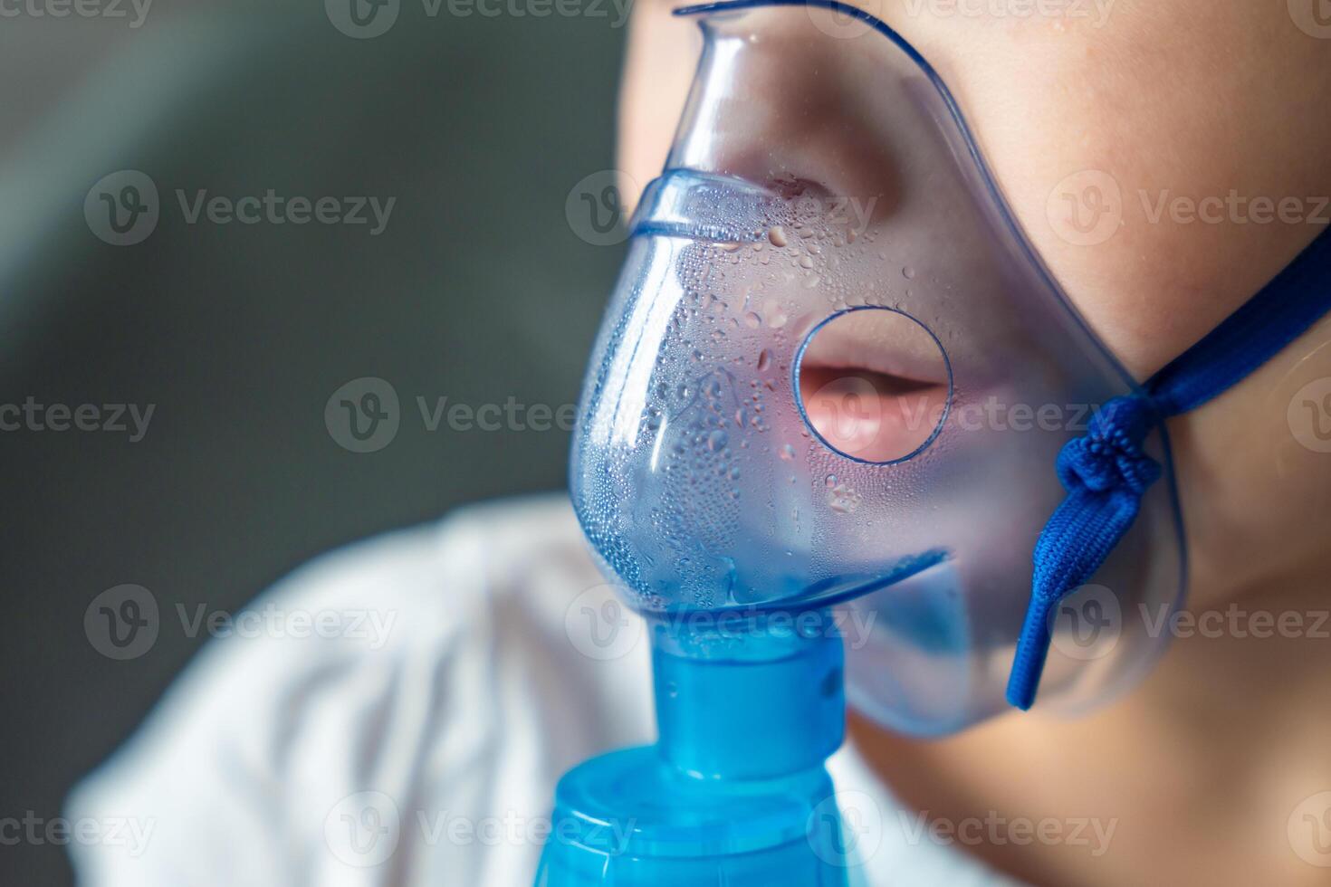 Close up view of little girl are sitting and holding a nebulizer mask leaning against the face, airway treatment concept photo