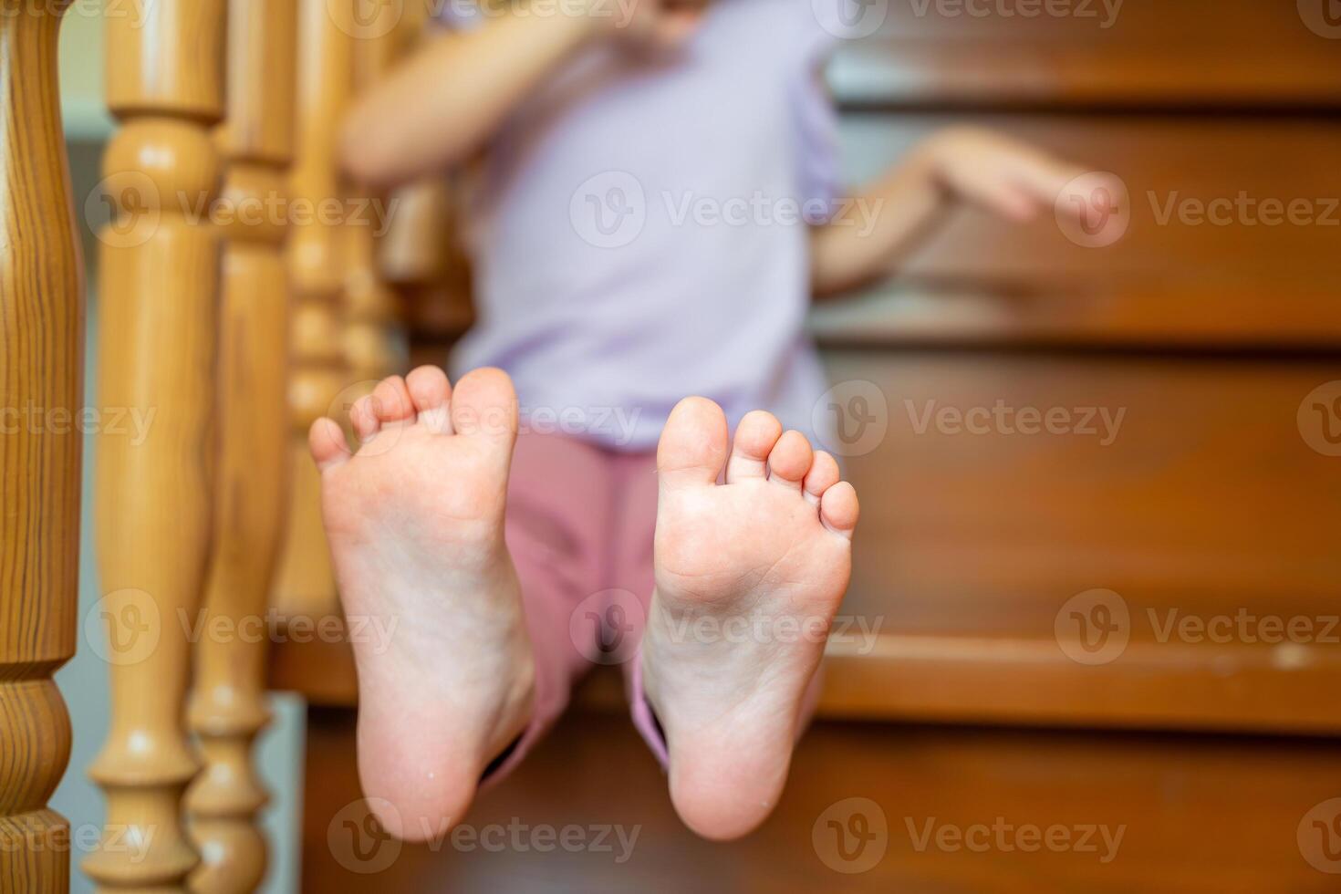 Closeup of infant toddler feet, child sitting on stairs at home photo