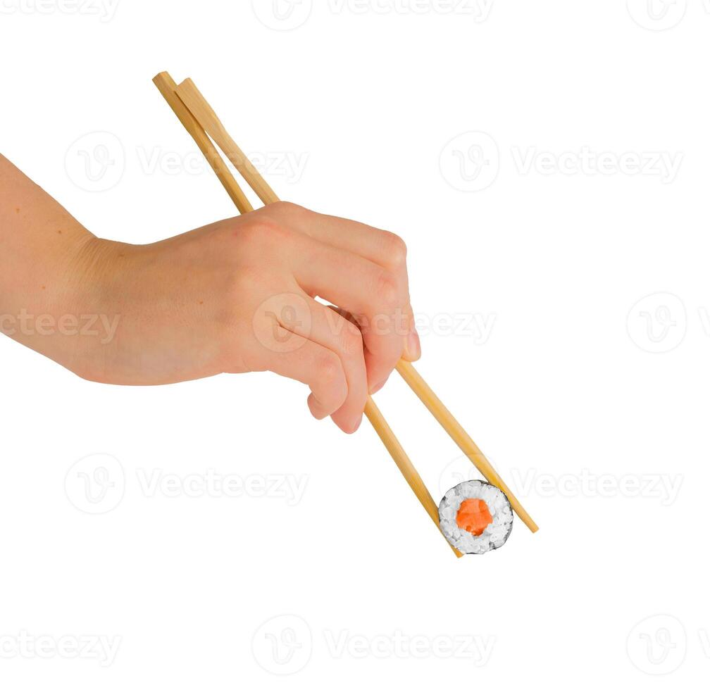 Hand with chopsticks eating maki roll, sushi with rice and salmon, isolated on white photo