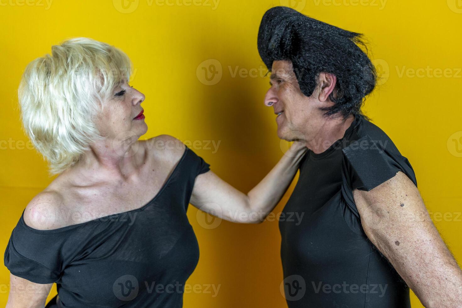 attractive elderly couple dressed in 50's style isolated on colorful background photo