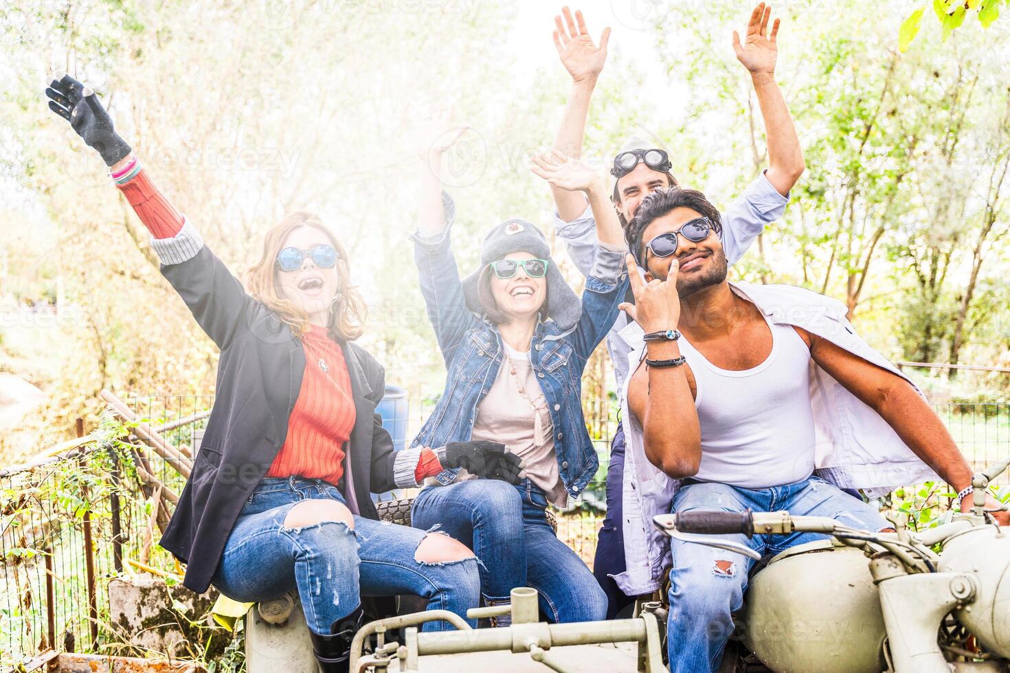 group of best friends together have fun riding a vintage motorcycle with sidecar photo