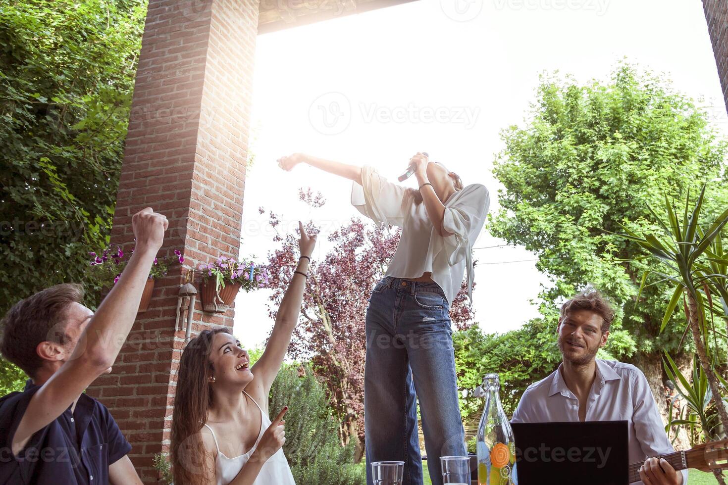 group of young friends having fun singing a song photo