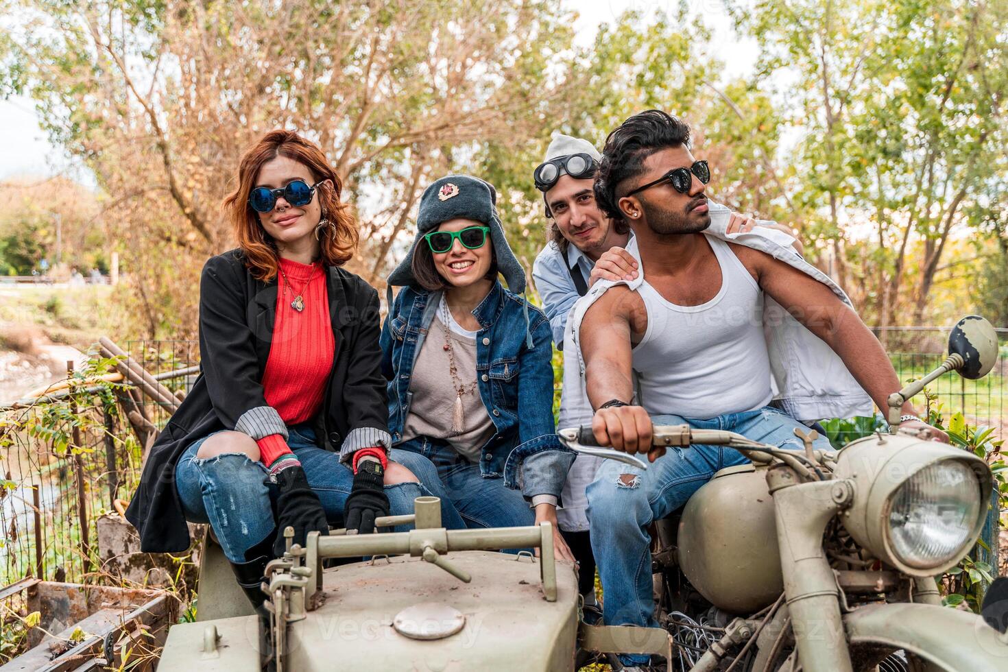 group of best friends together have fun riding a vintage motorcycle with sidecar photo